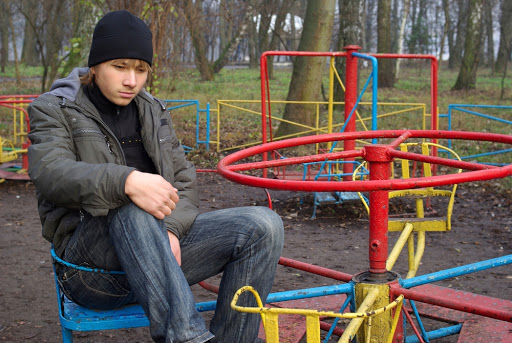Sad boy at a old abandoned playground