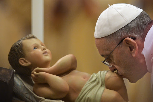 Pope Francis kisses the unveiled baby Jesus during a Christmas Eve mass at St Peter&#8217;s Basilica &#8211; it