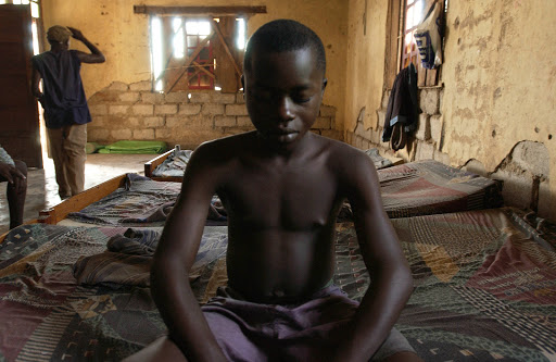 A Congolese boy, ex rebel, sits on a bed of a center for demobililized war children &#8211; it