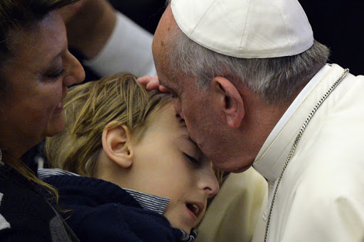 Pope Francis kisses a child during a meeting with blind and deaf people &#8211; it