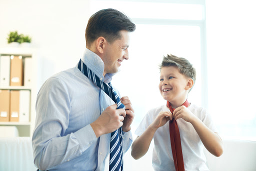 Happy boy and his father tying neckties