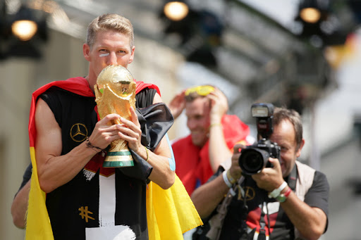 Bastian Schweinsteiger (L) kisses the World Cup trophy during the welcome reception for Germany&#8217;s national soccer team/Brandenburg Gate, Berlin, Germany, 15 July 2014. &#8211; it