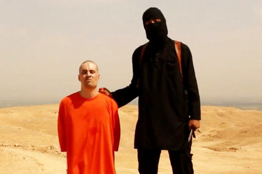 Syrian, Unknown : A videograd shows a masked Islamic State (ISIS) militant holding a knife speaks next to man purported to be U.S. journalist James Foley &#8211; it