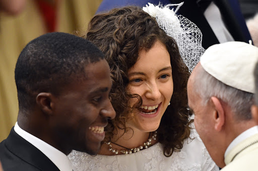Pope Francis (R) speaks with a young couple &#8211; it