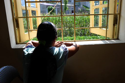 A woman looking out from a window at a centre for trafficked women in the northern city of Lao Cai &#8211; it