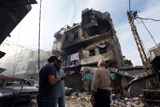 Men stand near war-damaged building in Tripoli, Lebanon &#8211; it