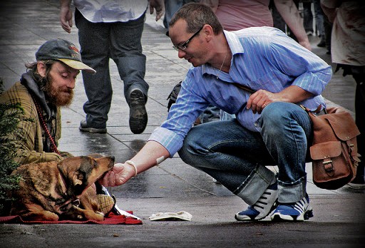 hombre acaricia el perro de un mendigo &#8211; it