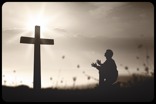 A man praying over the cross © CHOATphotographer / Shutterstock​ &#8211; it