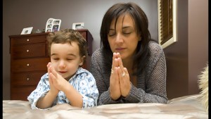 Young mother praying with child © Tony Bowler / Shutterstock – it