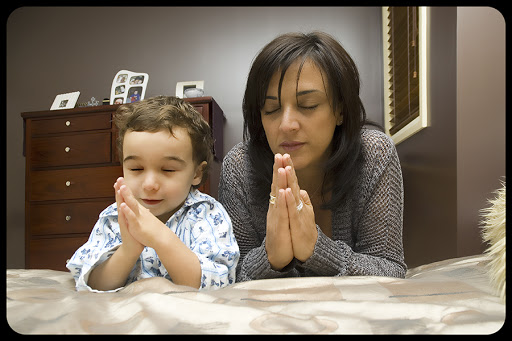 Young mother praying with child © Tony Bowler / Shutterstock &#8211; it
