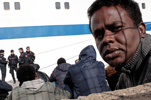 Migrants wait at the port of Lampedusa &#8211; AFP