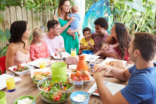Group of families enjoying outdoor meal at home © Monkey Business Images / Shutterstock