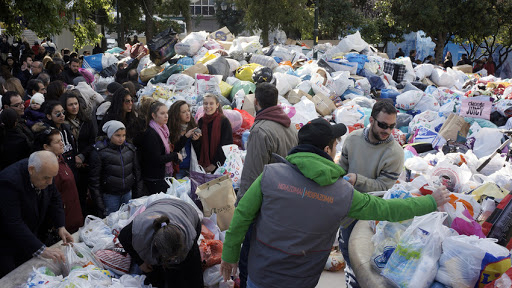 Volunteers help pass out free items to the poor in Athens &#8211; it