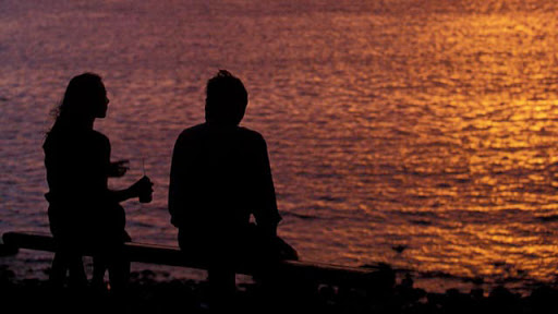 Couple sur la plage devant un coucher de soleil, à l’île de la Réunion
