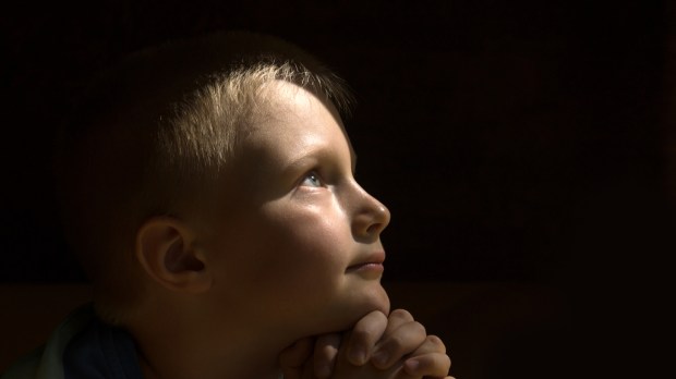 web-young-child-praying-dark-background-oksana-mizina-shutterstock_303404972