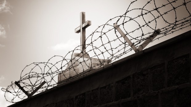 Religion and war concept &#8211; cross behind barbed wire