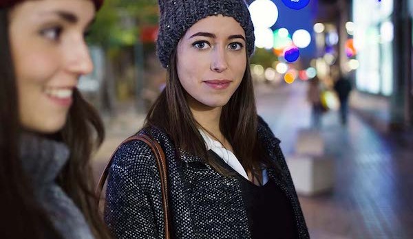Beautiful young woman looking at camera at night.