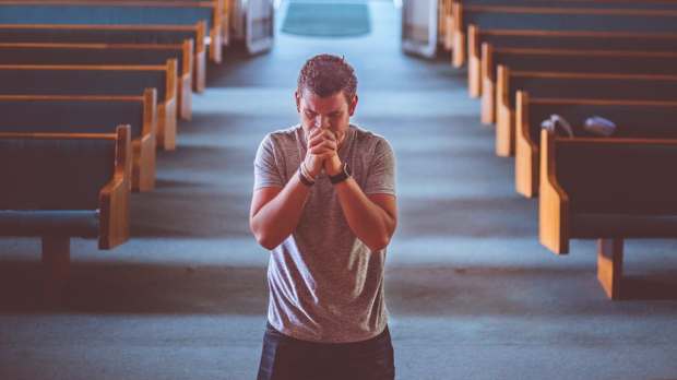 young man praying knee church