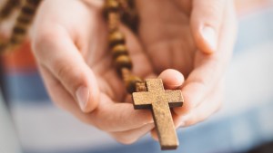 WEB3-BOY-CHILD-CATHOLIC-CROSS-ROSARY-PRAY-KID-Daniel-Jedzura-Shutterstock