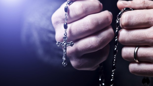 Closeup image of hands and rosary