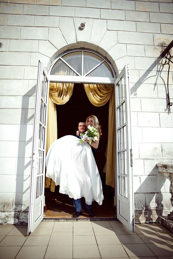 web3-groom-carrying-bride-door-wedding-day-shutterstock_289584017-ivashstudio-ai