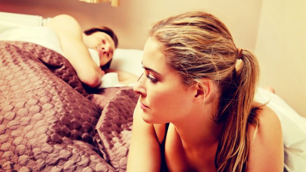 WEB3-Unhappy-woman-lying-in-bed-stressed-when-her-husband-sleeping