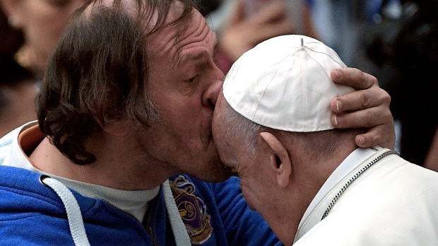 Pope Francis is kissed by a person
