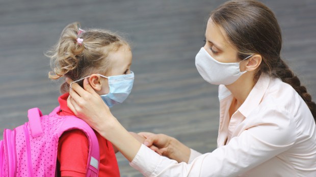 WEB3-A-mother-carefully-adjusts-her-little-daughters-medical-mask-Shutterstock_1788711782.jpg