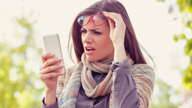 WOMAN LOOKING AT PHONE CONFUSED