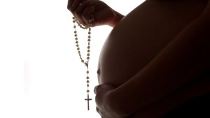 Nine-months-pregnancy-holding-a-rosary-shutterstock