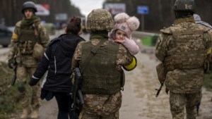 Żołnierze ukraińscy niosą dziewczynkę