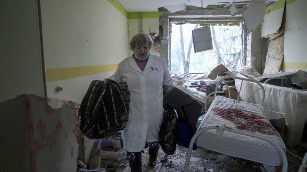 A medical worker walks inside of the damaged by shelling maternity hospital in Mariupol, Ukraine