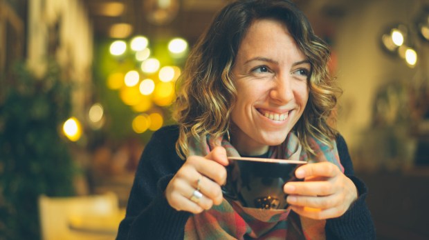 donna con smart phone in caffetteria